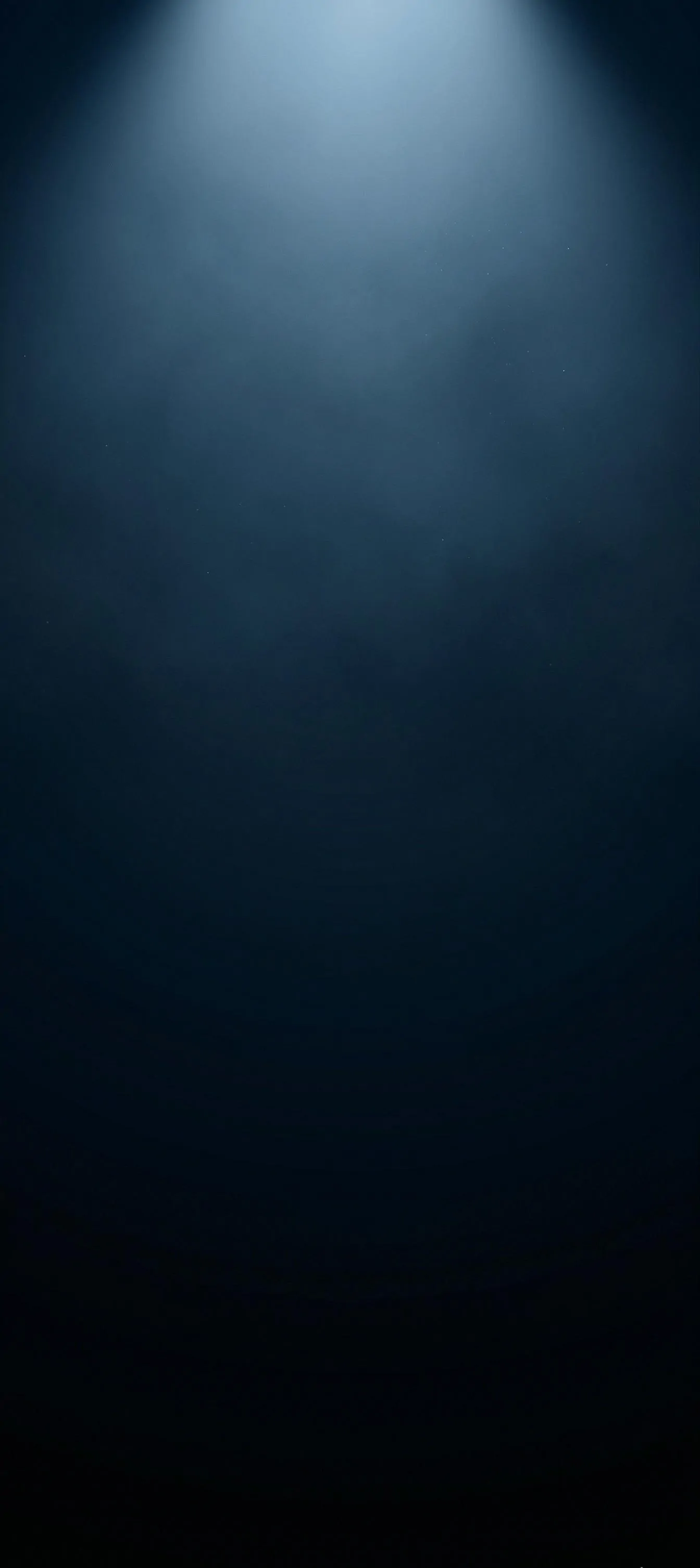 A high-quality dark blue textured background featuring a single, smoky cool blue spotlight ray shining from the top. Ideal as a backdrop for product displays, presentations, or website banners. Vertical orientation. dark-blue-background-with-top-spotlight